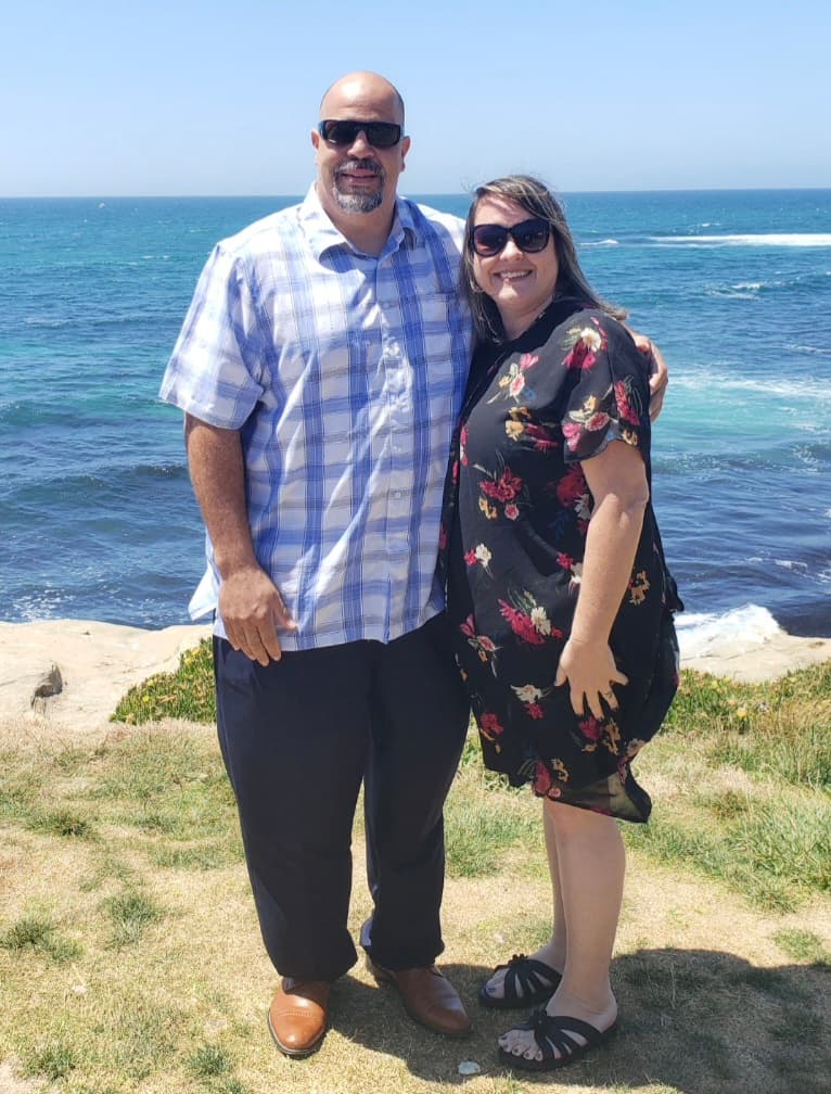 Daniel and Kim Fortune standing together along the California coast.